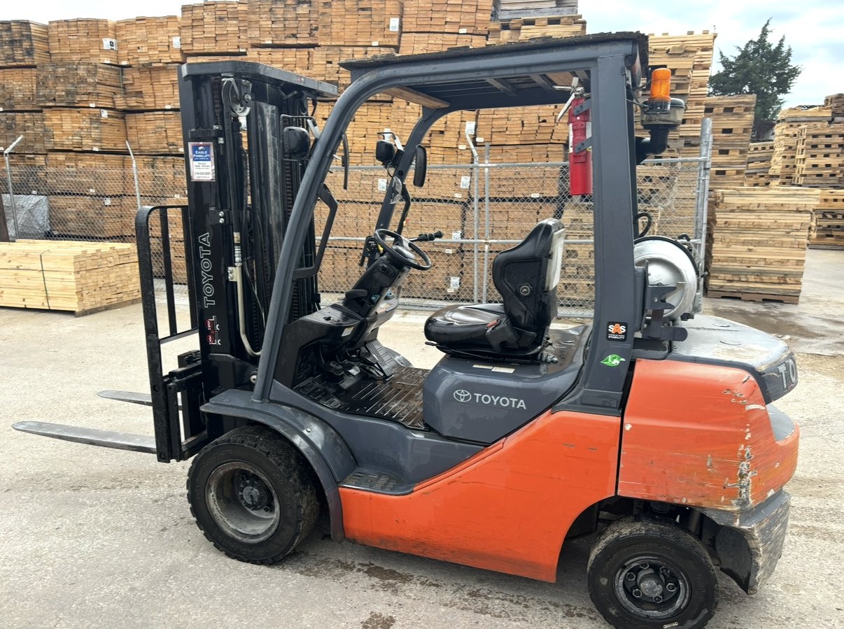 Used Toyota pneumatic-tire LP forklift parked at a lumber yard, offered to International Forklift Buyers for cash