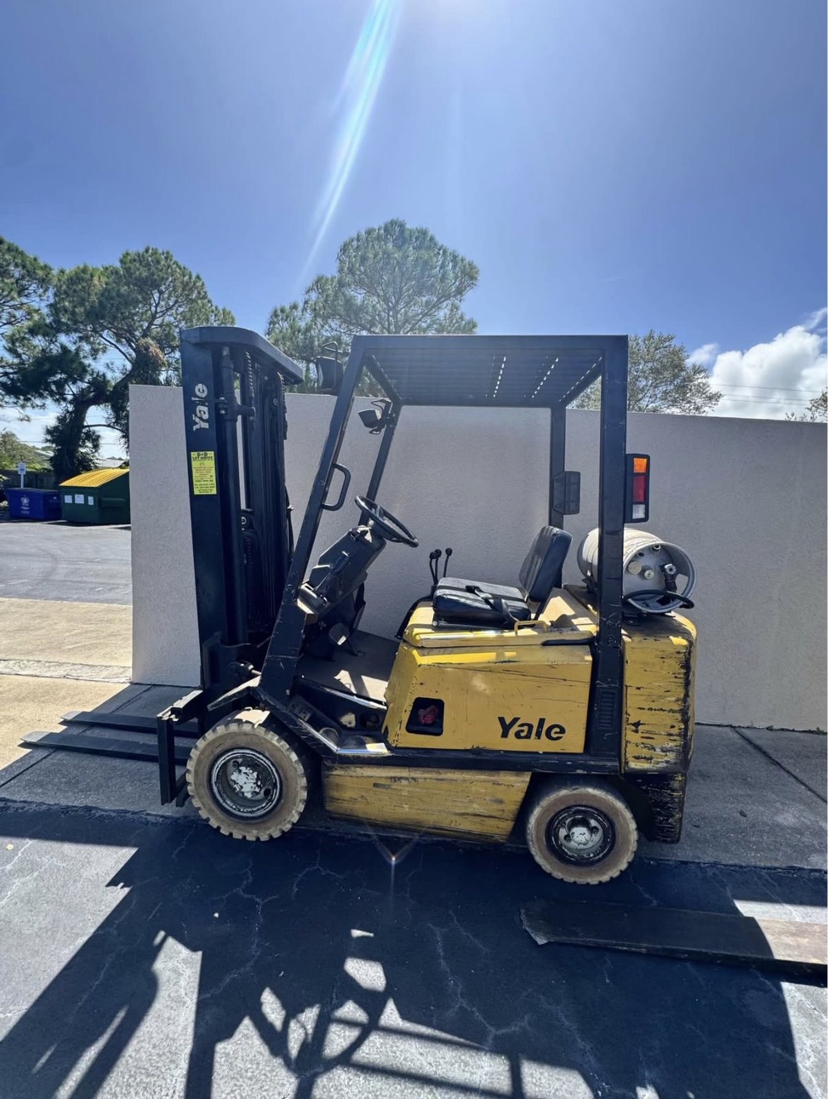 Used Yale cushion-tire forklift with propane tank parked on asphalt, side profile