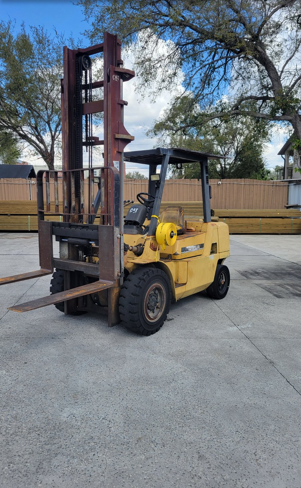Caterpillar pneumatic-tire forklift photographed head-on showing mast, carriage and forks